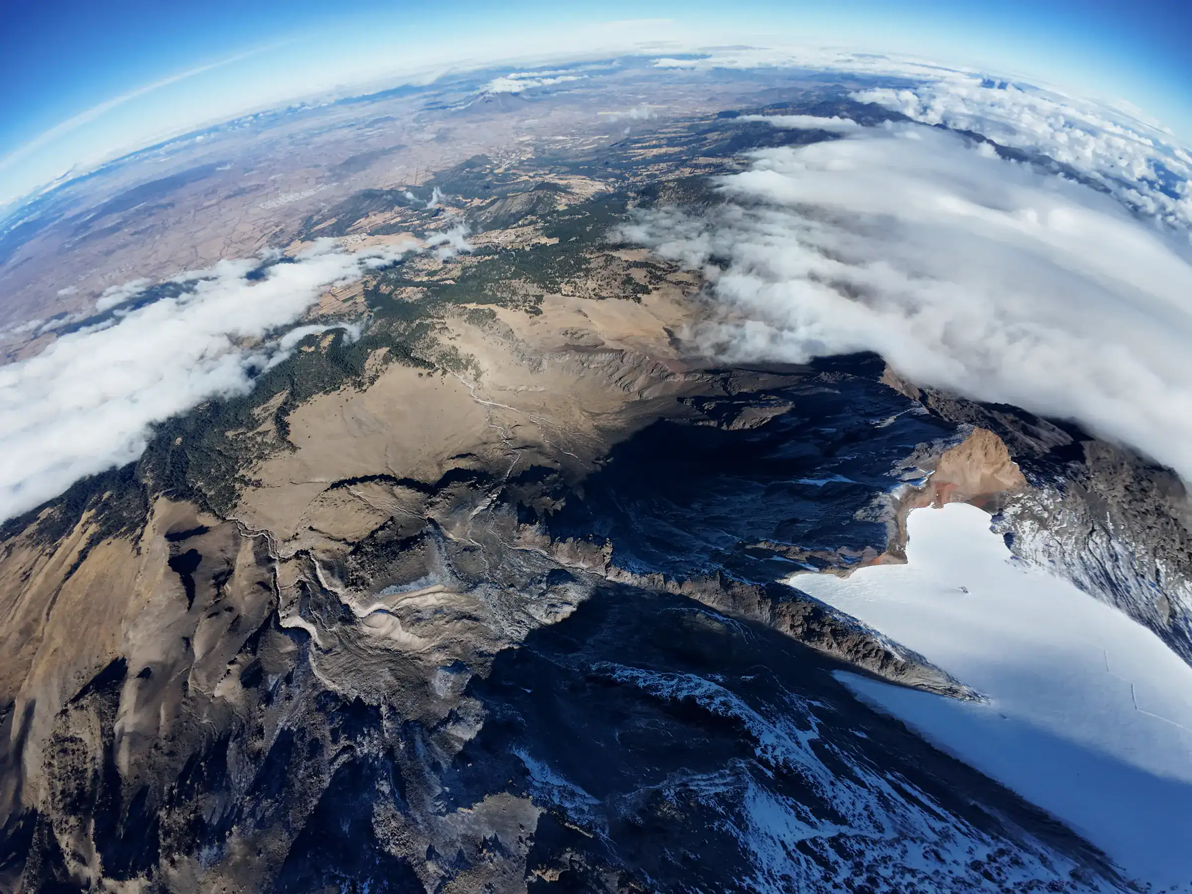 Vista aérea del cráter nevado del Pico de Orizaba asomando sobre el mar de nubes.