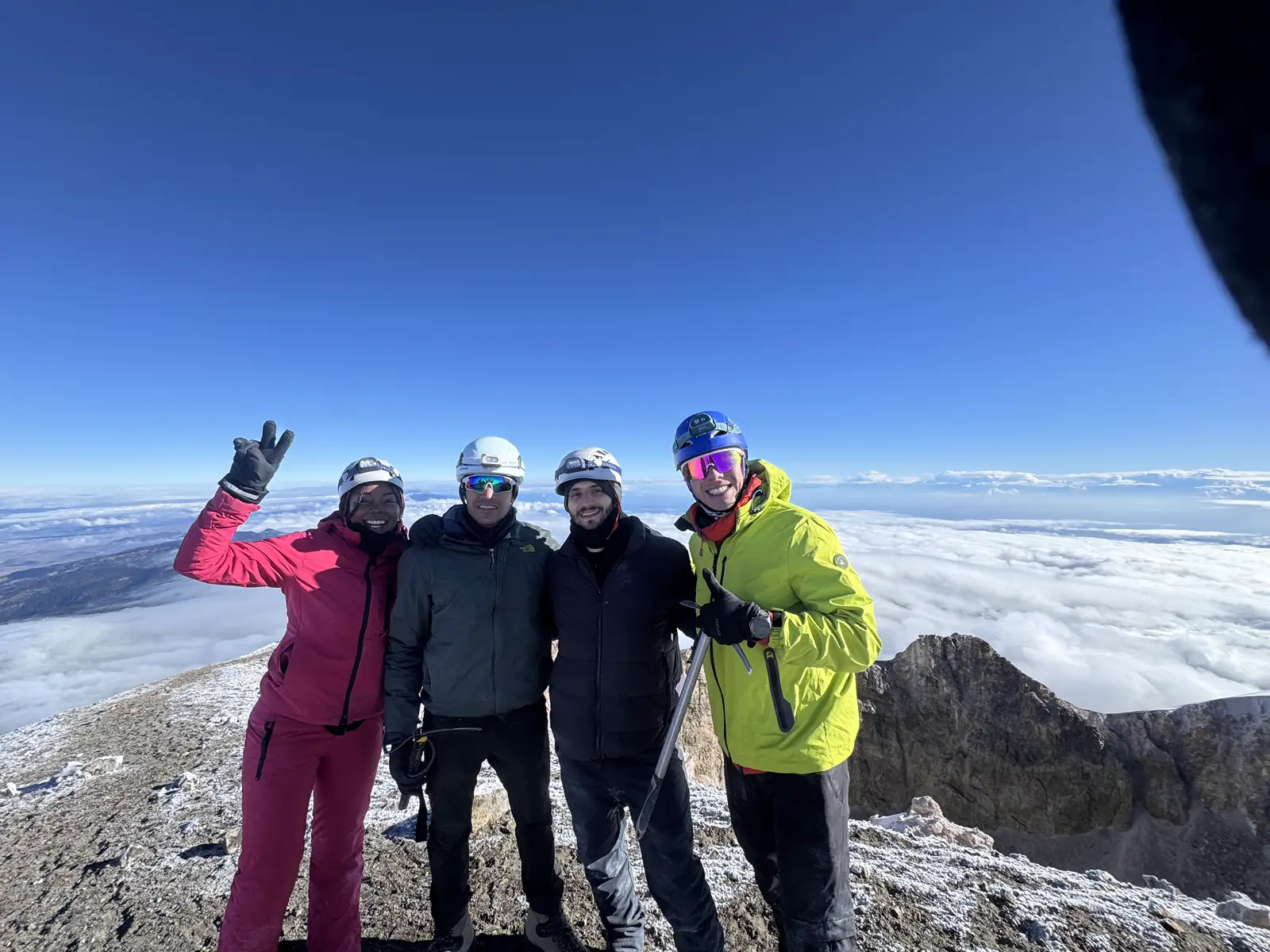 Grupo celebrando en la cumbre del Pico de Orizaba, sobre el mar de nubes.