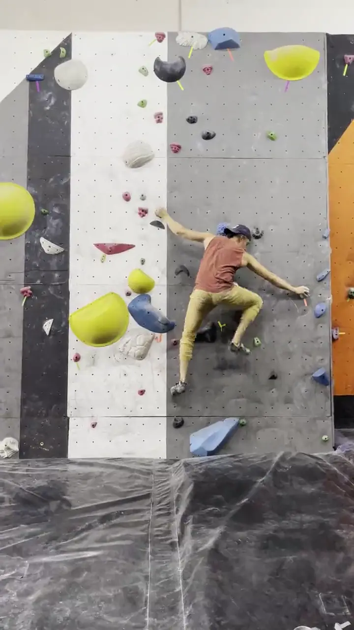 Escalador entrenando en un muro techado.
