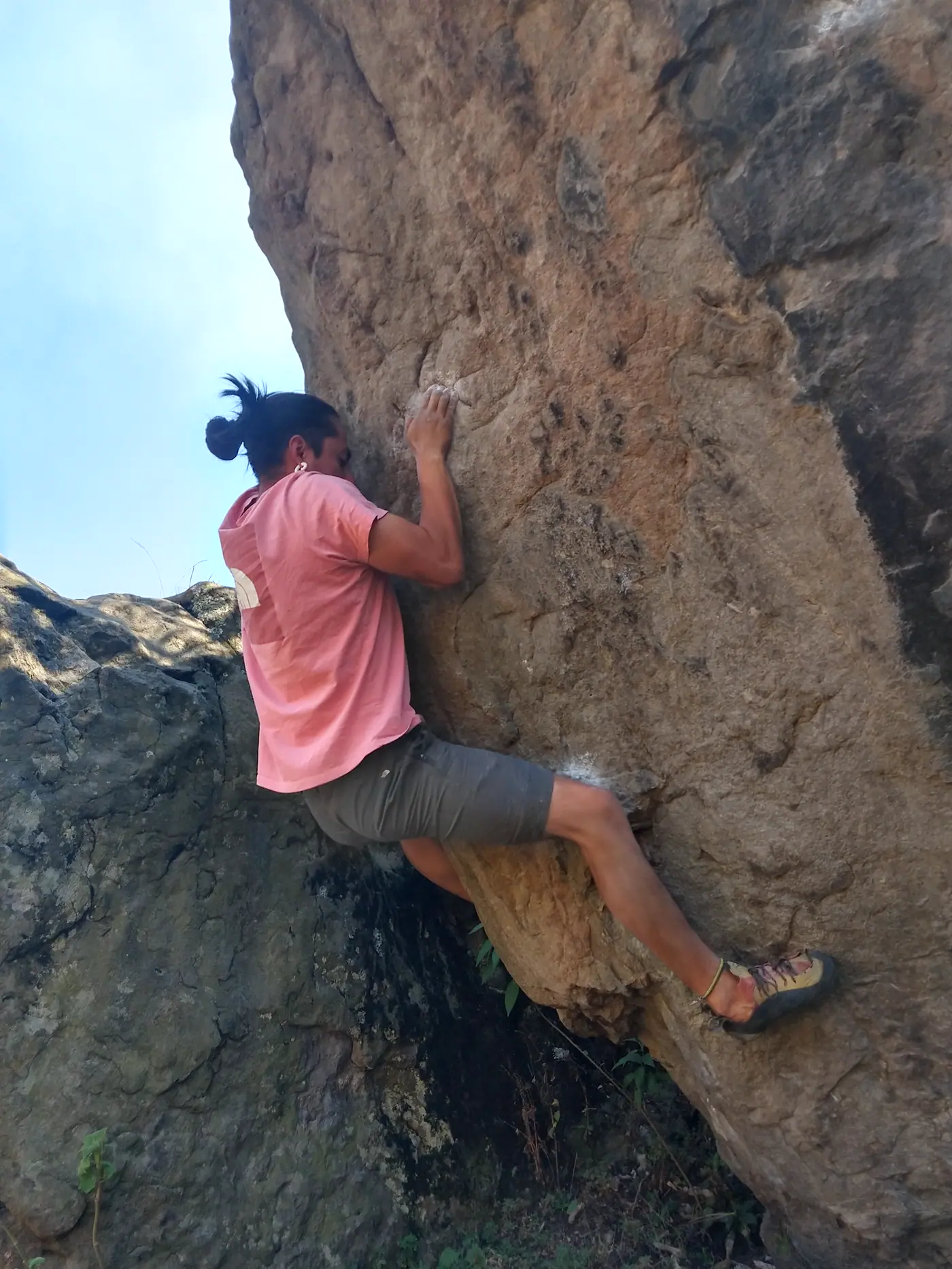 Escaladora subiendo una pared de roca.
